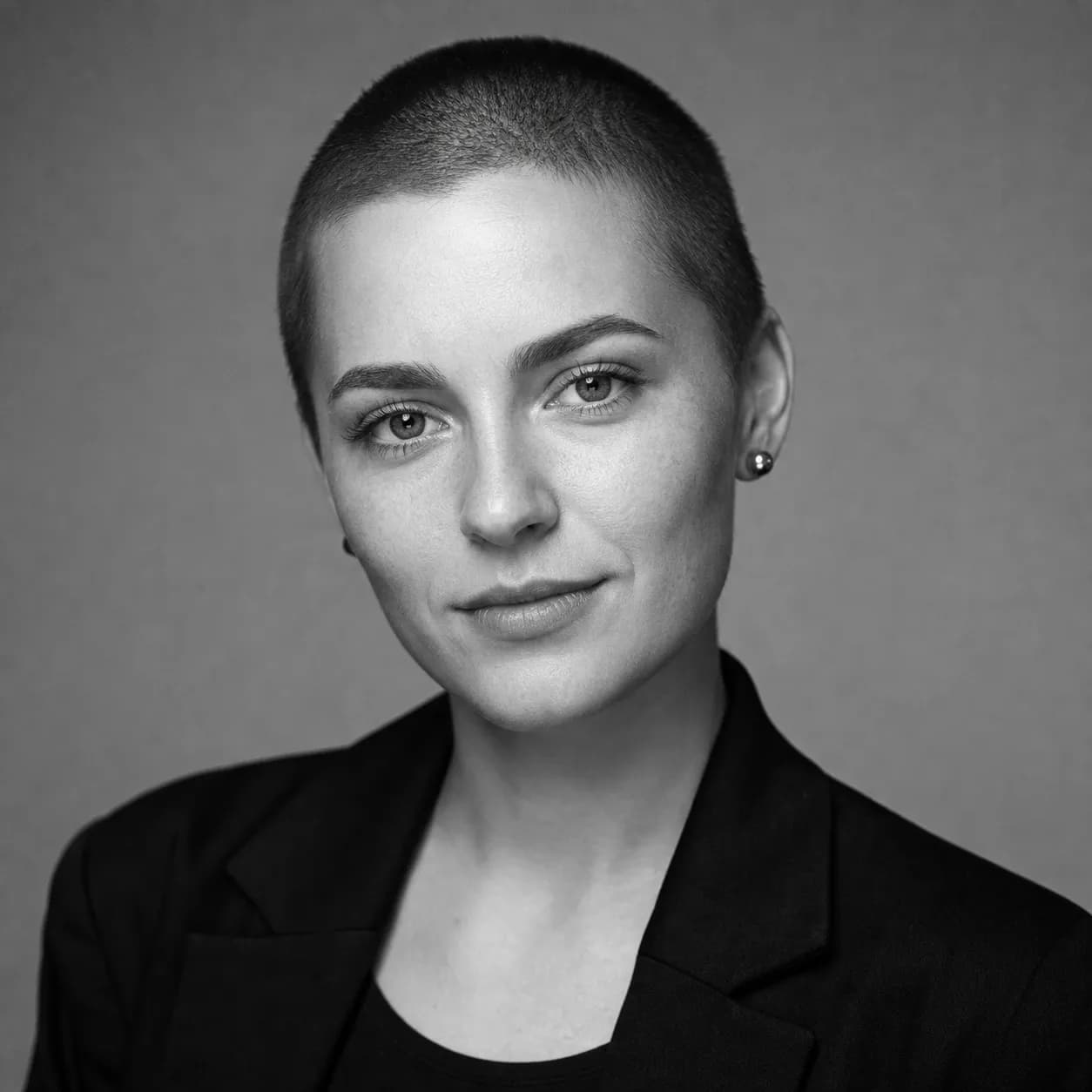 Black and white studio portrait of a presenter with a buzz cut