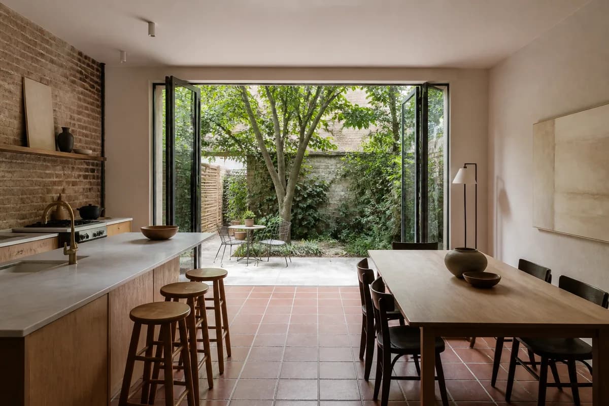 A Cobble Hill garden apartment opening through glass doors onto a small walled garden with a mature tree